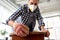 woman in respirator sanding old table with sponge