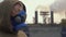 A woman in a respirator stands on the background of smoking factory pipes