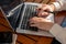 A woman responding to emails on her laptop computer, typing on the keyboard, and working online