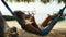 Woman is resting in hammock browsing pages in smartphone in ocean sand beach.