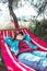 woman resting laying down in hammock between trees