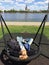 A woman is resting in a park on a swing overlooking the Daugava River and the old town of Riga on the other side