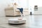 Woman resting while robotic vacuum cleaner doing her work