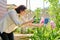 Woman resting in spring garden, photographing on smartphone flowering plant iris