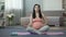 Woman restoring inner harmony and balance, doing yoga before giving birth