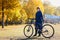 Woman retirement age with bicycle in autumn