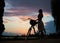 Woman with retro bike under the sky at sunset. Enjoying beautiful view of evening sky with clouds colorful in summer