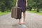 Woman with retro vintage luggage on empty street