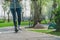 Woman ridding on kick scooter on pavement in park