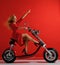 Woman ride new electric car motorcycle bicycle scooter with hands pointing finger up freedom sign laughing smiling