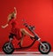 Woman ride new electric car motorcycle bicycle scooter with hands spread freedom sign laughing smiling on red background