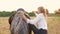 woman rider rides a horse in a field at sunset, slow motion