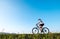 Woman rides a bicykle by the country road