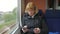 A woman rides the high-speed train and pay with a credit card via phone.