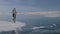 Woman is riding bicycle on the ice. The girl is dressed in a silvery down jacket, cycling backpack and helmet. Ice of