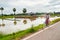 Woman riding a bike through a small village outside of Angkor Wat, Siem Reap, Cambodia. September 3, 2015