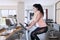 Woman riding exercise bike in fitness center
