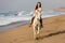 Woman riding horse beach