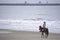 Woman riding a horse on the beach Background sea at Hua Hin Beach , Prachuap Khiri Khan in Thailand. March 15, 2020