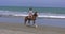 Woman riding a horse on the sand on a sunny day