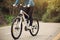 Woman riding mountain bike on forest trail