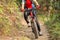 Woman riding mountain bike on outdoor trail in forest