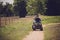 Woman riding quad atv vehicle running on dirt field