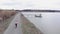 Woman riding on road bike near dam. Triathlete is pedalling on bicycle outside. Cyclist training on bike in park with lake on grav