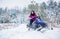 Woman is riding snowmobile in mountains. Girl on a sports snowmobile in a mountain forest. Athlete rides a snowmobile in