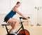 Woman riding stationary bicycle in health club