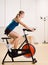 Woman riding stationary bicycle in health club