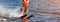 Woman riding water skis closeup. Body parts without a face. Athlete water skiing and having fun. Living a healthy