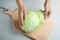 Woman with ripe cabbage at table