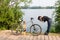 A woman by the river bent down to her bike to look at the breakdown