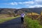 A woman on a road going through a wine district n the Mosel valley. Beautiful yellow vine leaves and green grass