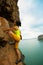 Woman rock climber climbing at seaside cliff