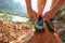 Woman rock climber tying shoelace at mountain rock