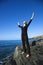 Woman on rocky coast.