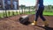 Woman with roller leveling soil earth in her apartment house yard. Gimbal motion