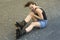 Woman with rollerblades sitting on asphalt in pain