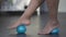Woman rolling massaging ball back and forth with foot, feet pain reliever