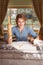 Woman with rolling-pin in the kitchen, bright emotional portrait