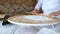 A woman with a rolling pin rolls out the dough for the cake. Roll out the dough with a rolling pin. The process of