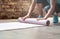 Woman rolling yoga pilates mat on gym studio floor, close up view
