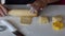 A woman rolls a dough on a table surface with a wooden rolling pin. Shapes it with his hands