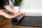 A woman rolls up a yoga mat after a workout in the studio