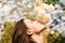 Woman with romantic face sniffs white or ivory roses