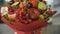 Woman rotating bouquet of fruits: lime, strawberry, pomegranate, marshmallow, apple