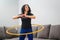 Woman rotating hula hoop. Girl training at home. Healthy sporty lifestyle
