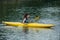 Woman rowing in the channel in yellow kayak
